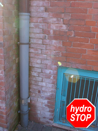 Salz an Klinkerfassade durch falsch montiertes Fallrohr, saurer Regen